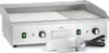 A stainless steel electric grill with a smooth plate on the left and a ribbed grill on the right, placed on a white background. Two spatulas are in the foreground. Náhled obrázku produktu