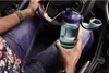 A person holding a Nalgene water bottle while sitting in the driver's seat of a car. Náhľad obrázku produktu