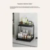A two-tiered black metal shelf organizer filled with various bottles and containers, likely for bathroom or kitchen use, placed on a countertop. Voir les images du produit