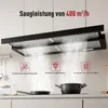 A kitchen scene with a range hood above a stovetop, featuring cooking pots and pans. Produktbild-Vorschau