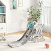 A young boy is playing on a colorful slide indoors, with a bookshelf and a plant in the background. Náhled obrázku produktu