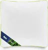 A white quilted pillow with a green trim and a blue label with text and an image of bamboo leaves. Náhľad obrázku produktu