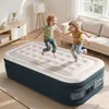 Two children jumping on an inflatable mattress in a living room. Produktbild-Vorschau
