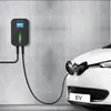 An electric vehicle charging station (wallbox) connected to a white electric car. Produktbild-Vorschau