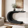 A black C-shaped console table with decorative vases and a plant on top, placed in a living room setting next to a sofa and a rug. Anteprima dell’immagine prodotto