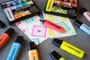 A collection of STABILO BOSS ORIGINAL highlighters scattered around a piece of paper with geometric patterns drawn on it. Anteprima dell’immagine prodotto