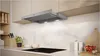 A modern kitchen scene featuring a range hood over a stovetop. Produktbild-Vorschau
