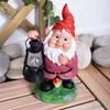 A garden gnome holding a lantern, standing on a patch of grass with a mushroom. Produktbild-Vorschau