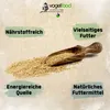 A wooden scoop filled with birdseed is placed on a pile of birdseed, with descriptive text boxes around it. Produktbild-Vorschau