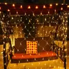 A porch swing decorated with a net of yellow fairy lights and a patterned pillow. Produktbild-Vorschau