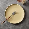 A single plate with a fork on a textured gray surface. Produktbild-Vorschau