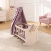 A nursery room with a rocking doll cradle decorated with rainbows. Produktbild-Vorschau