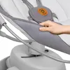 A close-up shot of a person's hand holding a gray fabric part of a baby swing. Produktbild-Vorschau