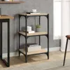 A three-tier shelf unit with wooden shelves and a black metal frame, placed in a room setting. Náhled obrázku produktu