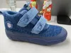 A blue children's shoe is placed on a desk with some decorative items in the background. Anteprima dell’immagine prodotto