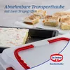 A baking tray with a transparent lid and red handles, with several slices of cake on paper in the background. Anteprima dell’immagine prodotto
