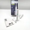 A Philips Sonicare electric toothbrush and its accessories are displayed on a white surface with a gray background. Produktbild-Vorschau