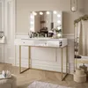 A modern vanity table with a lighted mirror, makeup, and decorative items in a well-lit room. Produktbild-Vorschau