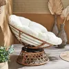 A papasan chair with a white cushion is placed in a room with decorative vases and dried palm leaves. Produktbild-Vorschau
