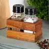A set of salt and pepper shakers in a wooden holder, placed on a table with a blue cloth. Náhľad obrázku produktu