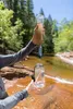 A person is filtering water from a stream using a portable water filter. Podgląd zdjęcia produktu