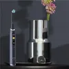 An electric toothbrush and a vase with flowers are displayed on a dark surface. Produktbild-Vorschau