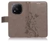 A brown flip case for a smartphone, decorated with a floral and butterfly pattern. Produktbild-Vorschau