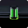 A close-up view of two green battery packs in a black and green holder, mounted on a dark surface. Podgląd zdjęcia produktu