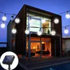 A modern house with outdoor string lights and a solar panel. Anteprima dell’immagine prodotto