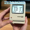 A person's hands are holding a retro-styled electronic clock that resembles an old computer. Produktbild-Vorschau