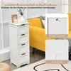 A white bathroom cabinet with four drawers is shown in a room with a yellow sofa and blinds in the background. Insets highlight safety features. Náhled obrázku produktu