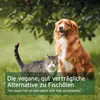 A cat and a dog are sitting on grass in front of a tree. Text is overlaid on the bottom of the image. Produktbild-Vorschau