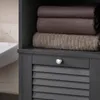 A close-up view of a dark gray bathroom cabinet with stacked towels and a louvered drawer. Náhľad obrázku produktu
