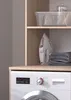 A close-up view of a washing machine and a shelf with laundry items. Produktbild-Vorschau