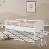 A child's bed with bedding and a small wooden airplane on a rug. Produktbild-Vorschau