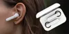 A close-up of a person's ear wearing a white wireless earbud, with a charging case containing two earbuds in the background. Produktbild-Vorschau