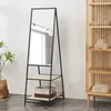 A full-length mirror with shelves is shown in a room with a plant and a wooden cabinet. Podgląd zdjęcia produktu