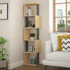 A modern bookshelf with decorative items and books, placed in a living room setting next to a sofa and a window. Produktbild-Vorschau