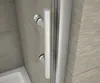 Close-up of a shower door handle and frame, with tiled walls and a shower base visible. Produktbild-Vorschau