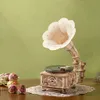 A wooden model of a vintage gramophone is displayed on a table with dried flowers. Podgląd zdjęcia produktu