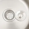A close-up view of a stainless steel sink drain with a removable strainer and a separate drain cover. Náhled obrázku produktu