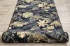 A rolled-up rug with a tropical leaf pattern on a wooden floor. Produktbild-Vorschau