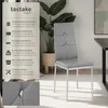 A grey dining chair with a silver frame is shown next to a potted plant, with a text overlay describing its features. Produktbild-Vorschau