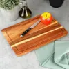 A wooden cutting board with an apple and a knife on it, placed on a countertop. Podgląd zdjęcia produktu