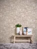 A vignette of decorative items on a wooden bench against a stone-patterned wallpaper. Náhľad obrázku produktu