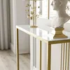 A close-up shot of a console table with a white glass top and gold metal frame, placed in a well-lit room with curtains and a bust on top. Náhľad obrázku produktu