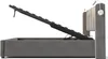 A side view of a gray upholstered bed frame with the mattress support lifted to reveal storage space underneath. A small lamp is attached to the headboard. Podgląd zdjęcia produktu