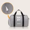 A grey duffel bag with the text 'BABY' and 'lionelo' printed on it, with a close-up inset showing a tissue dispenser feature. Náhľad obrázku produktu