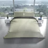 A bed with bedding is set up in a modern room with large windows overlooking a scenic landscape. Produktbild-Vorschau