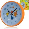 A close-up of a children's wall clock with cartoon characters on the face, set against a white background. A product box is visible in the upper right corner. Voir les images du produit